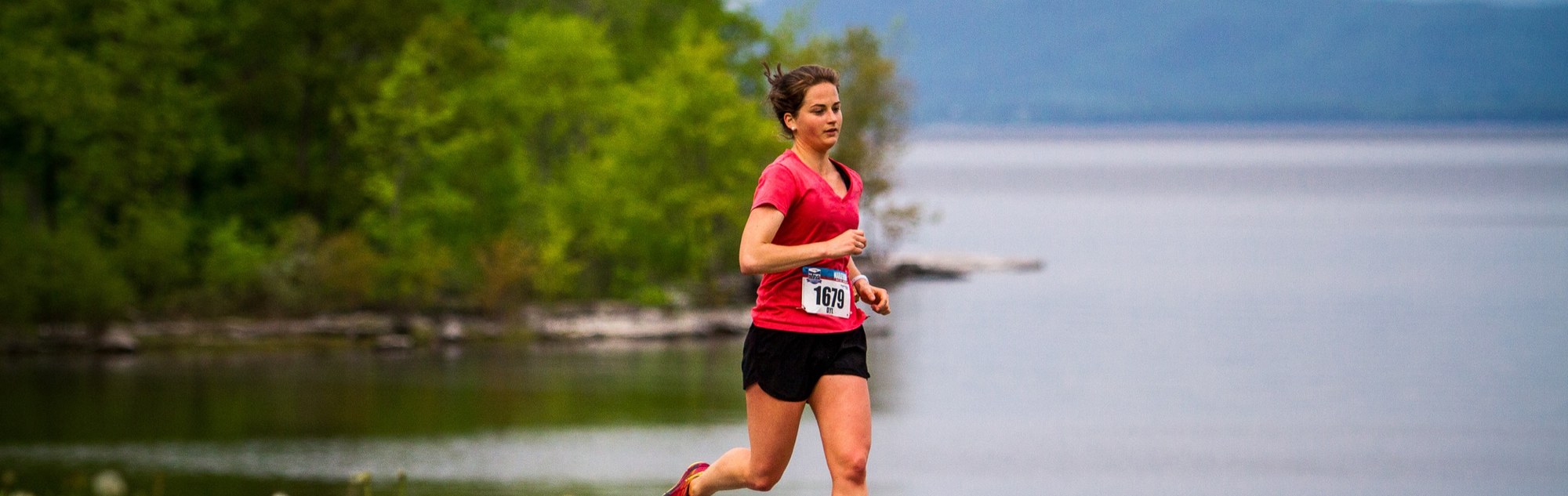 woman running in front of lake
