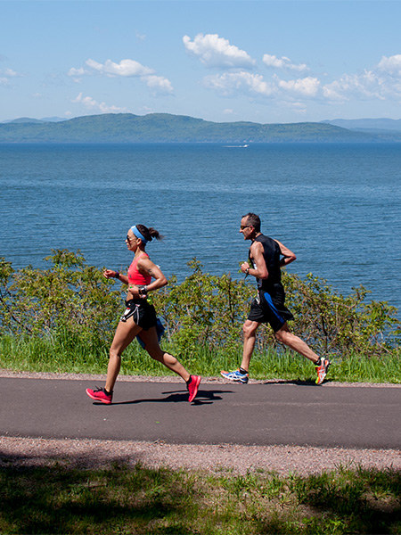 Runners running along lake Champlain