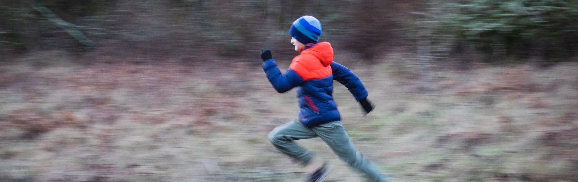 Boy running through field