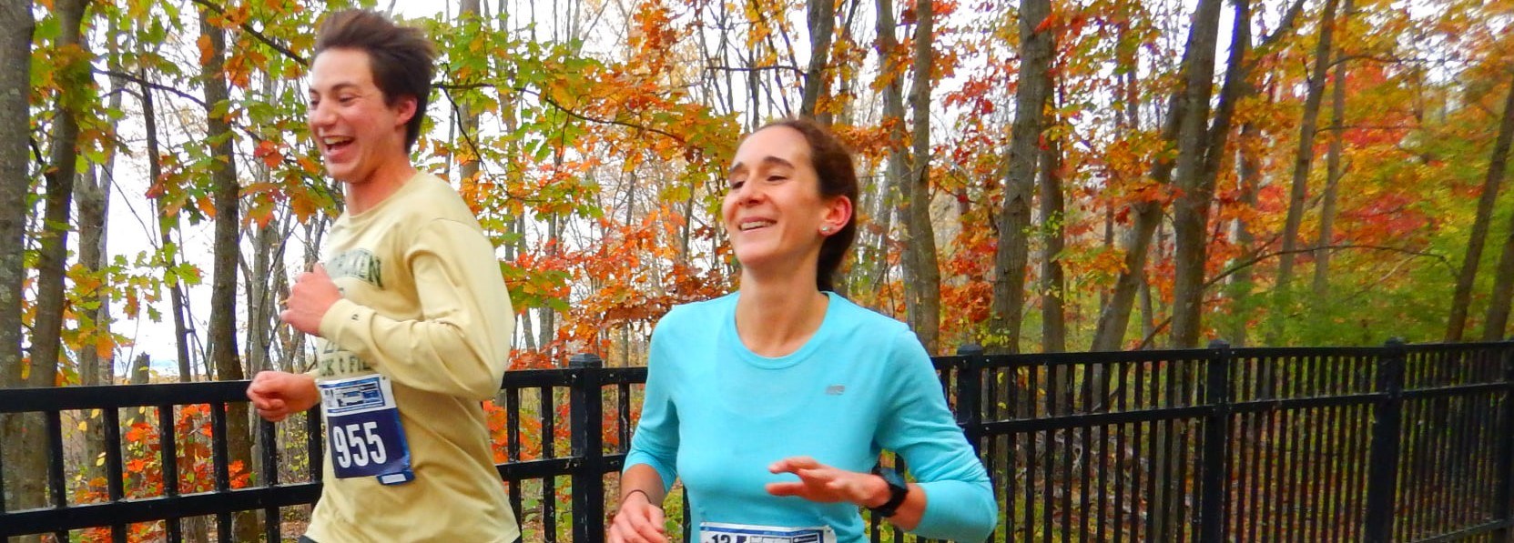 two smiling runners in the fall