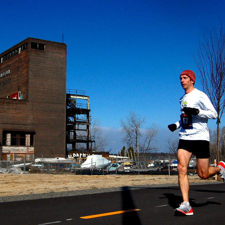 Runner passing an old building